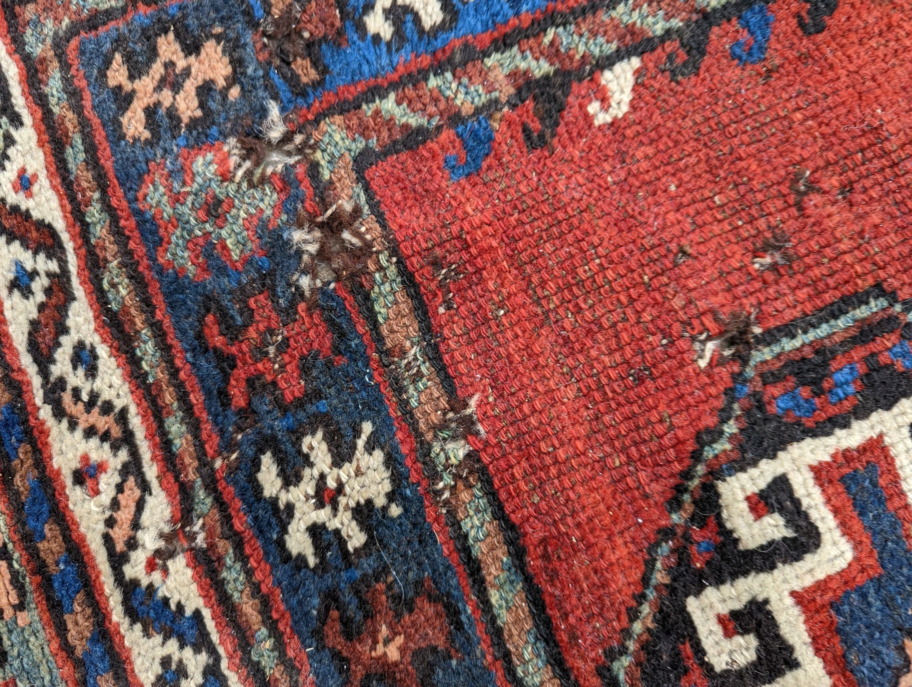 A Caucasian red ground rug, 210 x 110cm